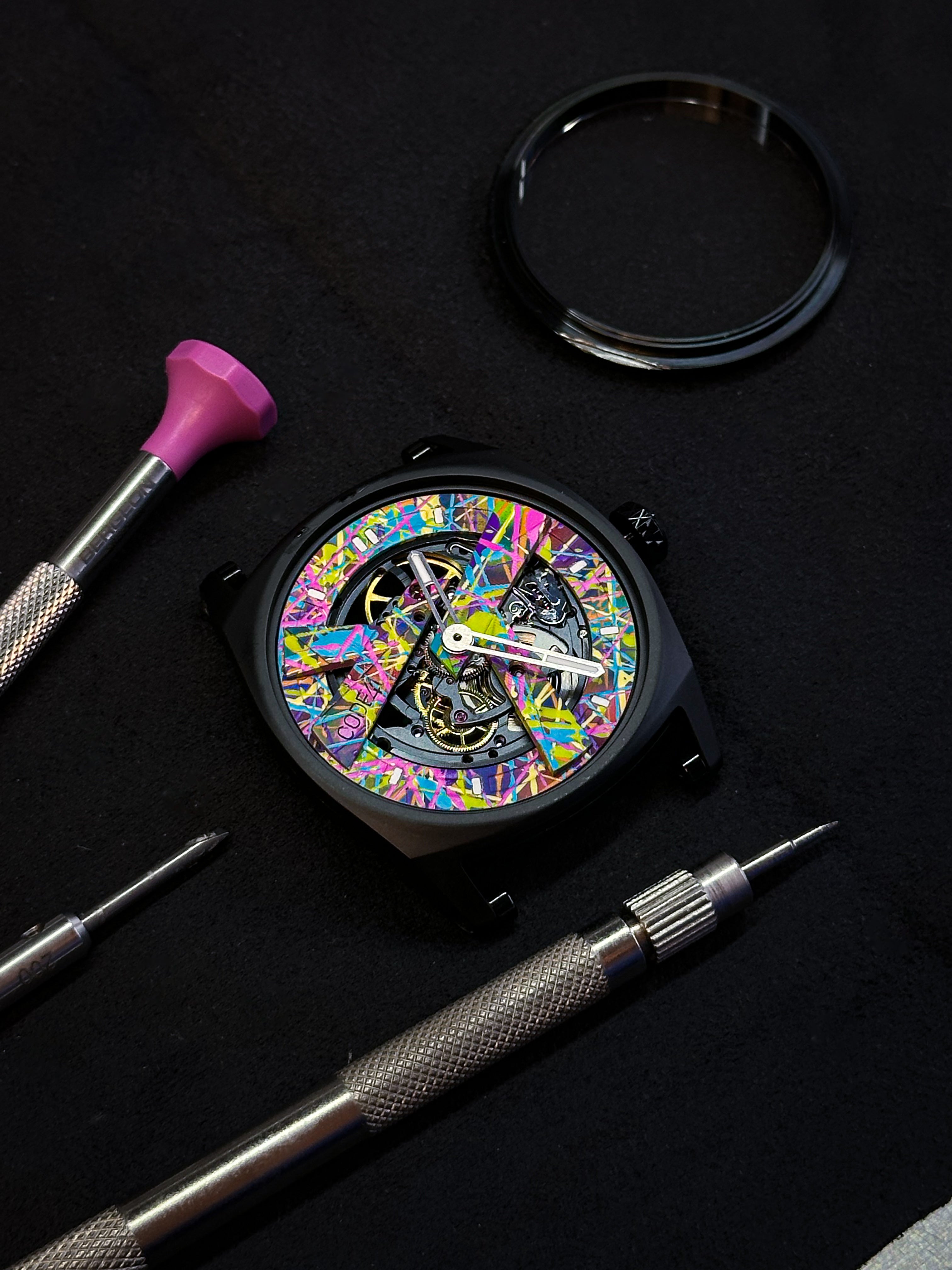 Colorful watch face with mechanical components on a black background